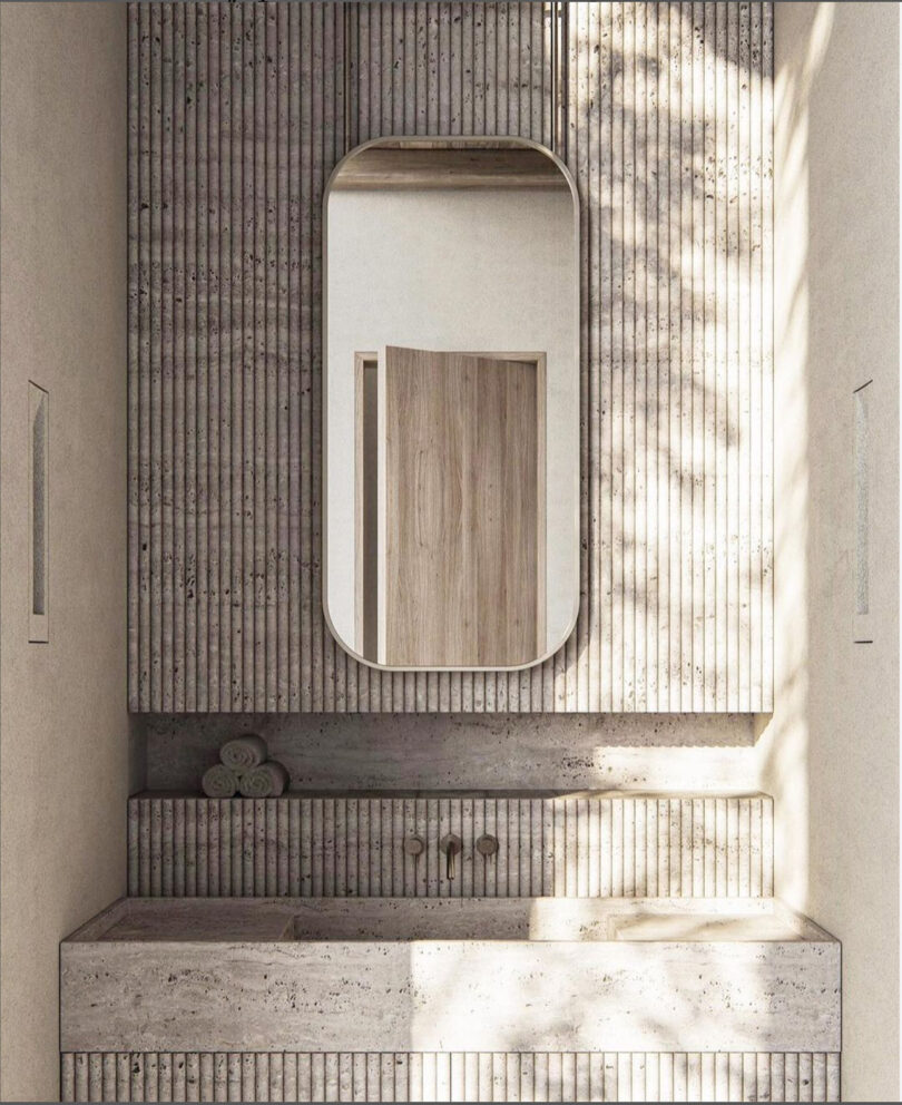 A minimalist Cosmic One ADU bathroom design featuring a wall-mounted mirror above a fluted concrete vanity with a wooden cabinet.