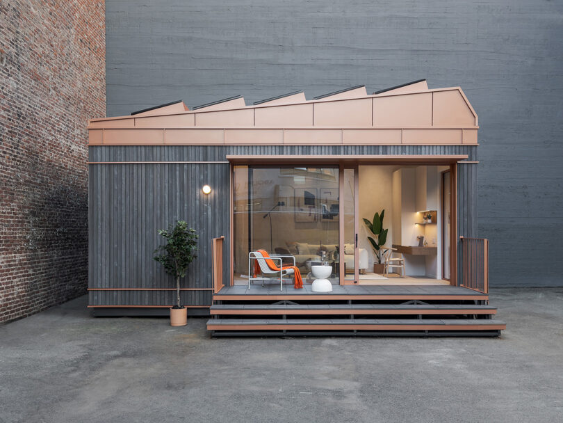 Modern Cosmic One ADU living space with minimalist design, featuring wooden accents and large windows, nestled in an urban outdoor setting.