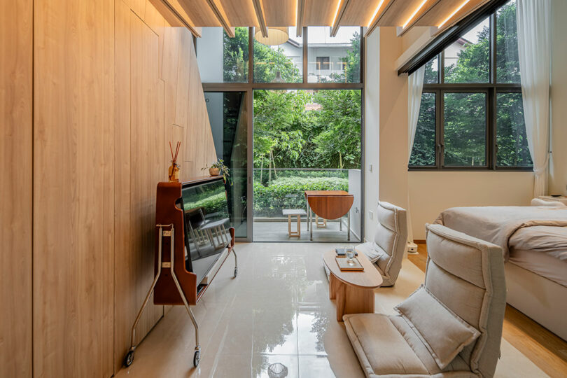 side view through small modern living room with two chairs with bedroom behind it